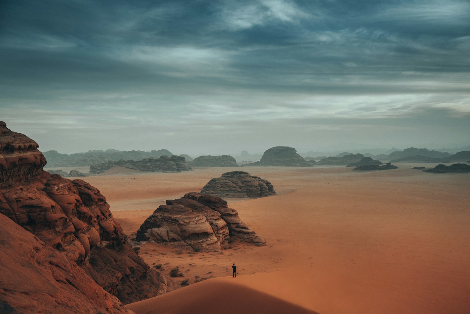 a person standing on a sand dune in the desert